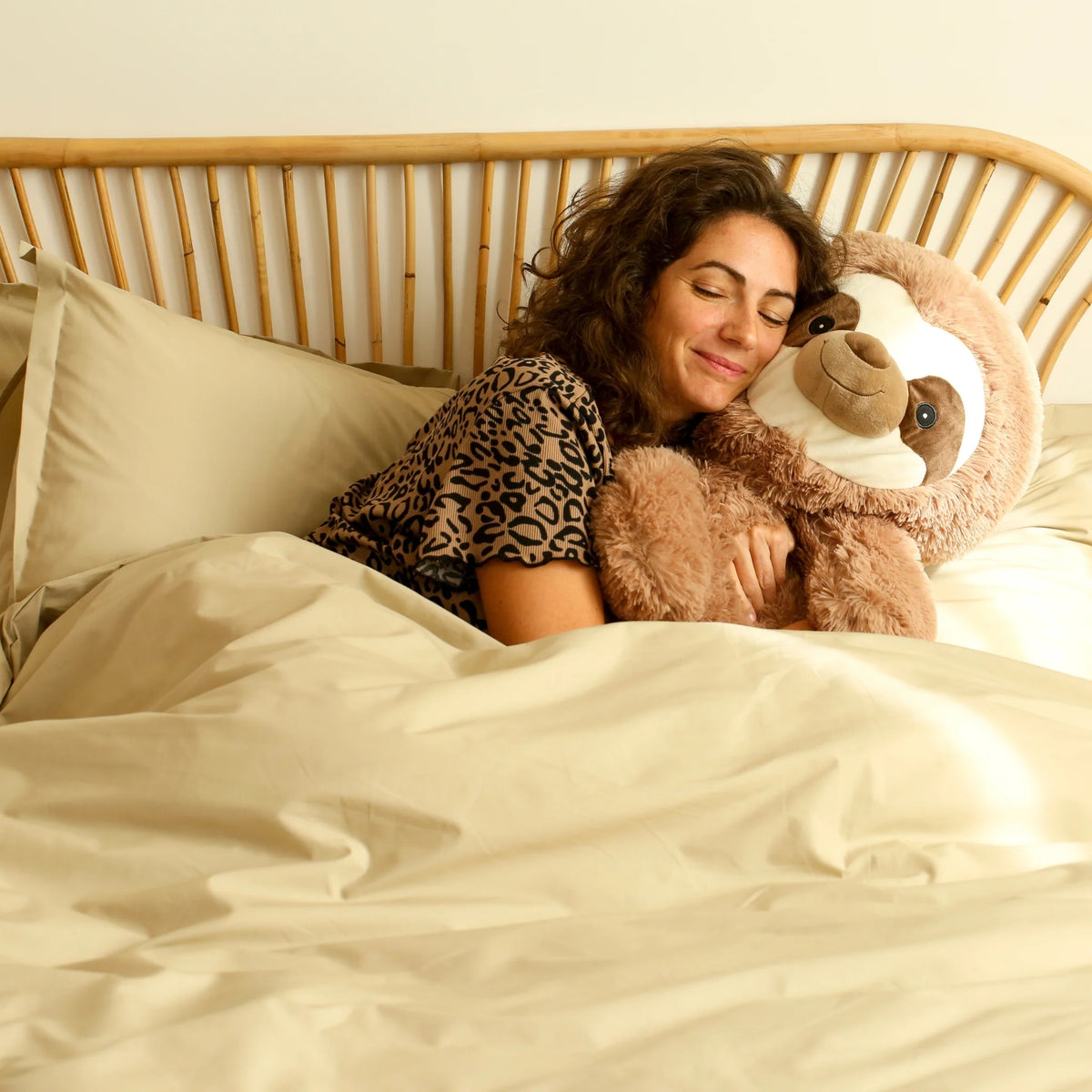 Photo de notre housse de couette anti-galère Hopoli (Osier) sur un lit avec une personne dedans